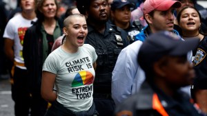 A climate activist continues to chant while under arrest