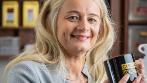 A woman holds a coffee mug