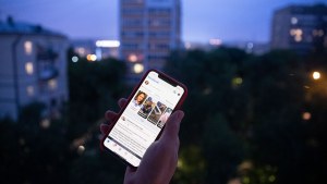 A user holds a smartphone with an opened Facebook page in Moscow, Russia