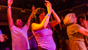 People singing and dancing during an indoor concert