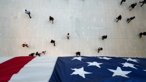 People walk under an American flag