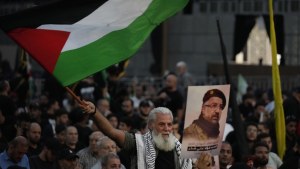 A Hezbollah supporter waves the Palestinian flag during the funeral procession of top commander Fouad Shukur who was killed by an Israeli airstrike