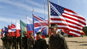 Soldiers from NATO countries hold their respective flags