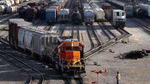 A railyard in Galesburg, Ill., shows various trains lined up awaiting track space, with a yellow-fronted BNSF engine in the front.