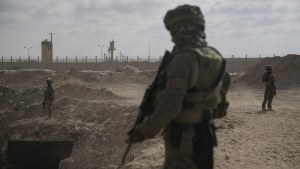 Israeli soldiers take up positions next to an entrance of a tunnel in Gaza